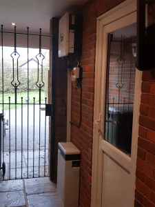 A battery storage device on a brick wall by a side door on a UK house